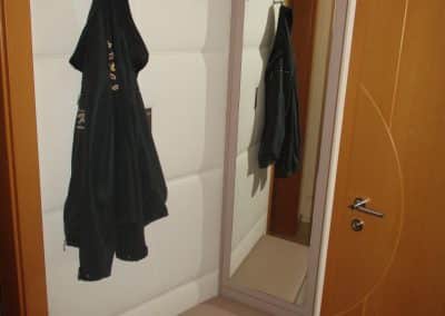 Gästegarderobe mit Lederwand und freischwebender Sitzgelegenheit. Spiegelpaneel zum öffnen.